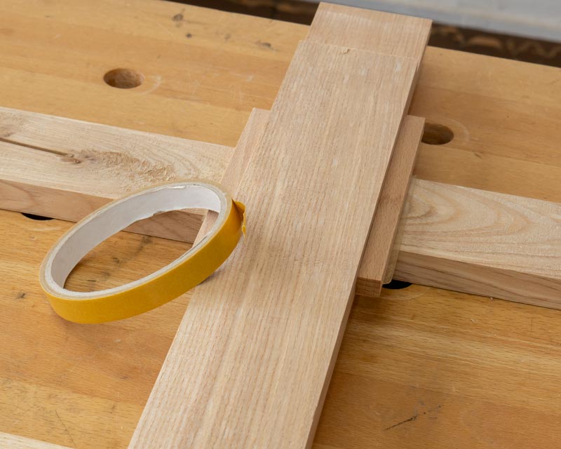 Die Position der Aussparung wird festgelegt. Zwei Leisten werden mit doppelseitigem Klebeband festgeklebt, dazwischen liegt das Querstück.