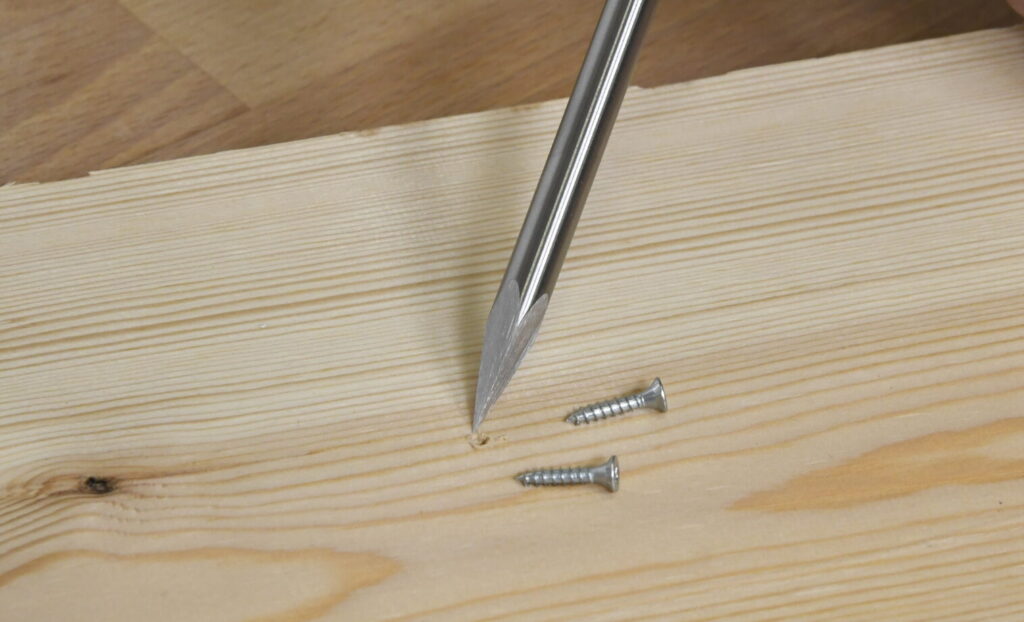 Mit der Bohrahle werden kleine Schraublöcher in das Holz vorgebohrt.