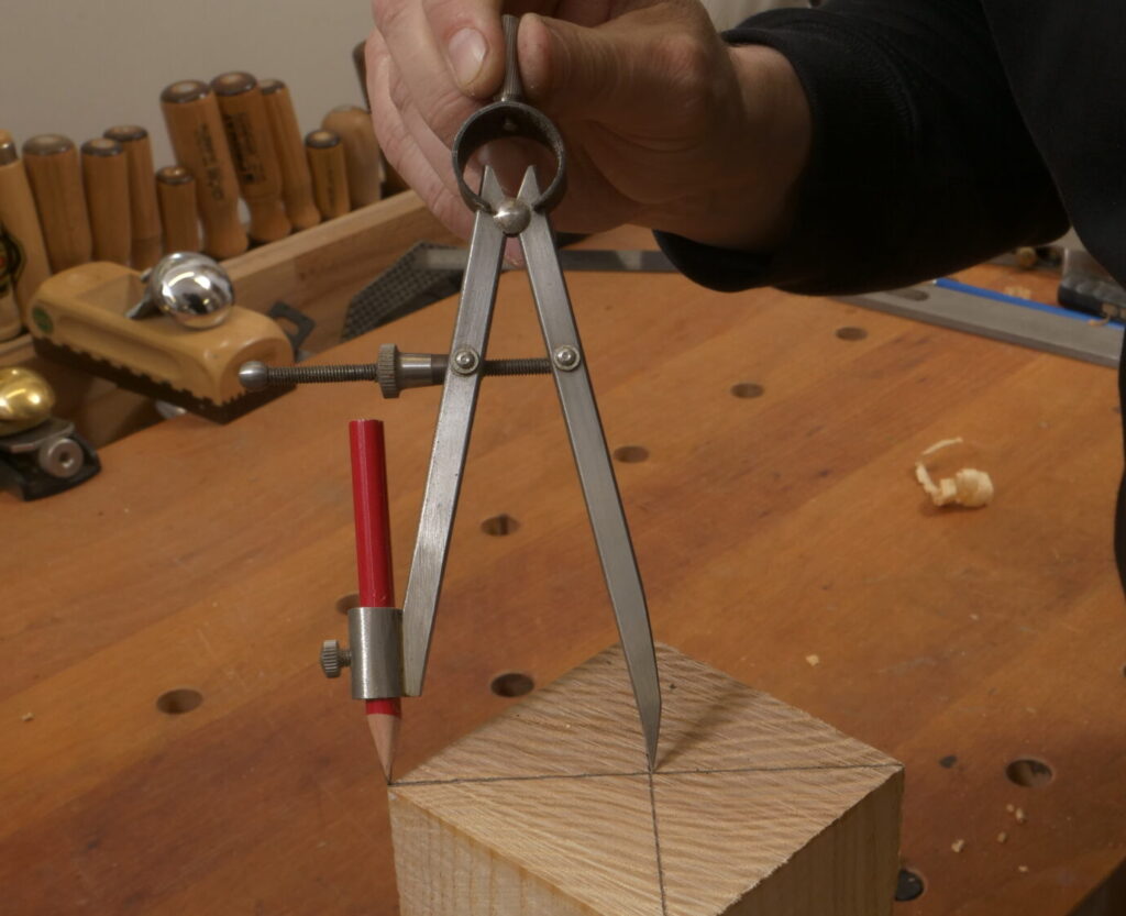 Ein Achteck wird mit Hilfe eines Zirkels auf den Pfosten eingezeichnet.