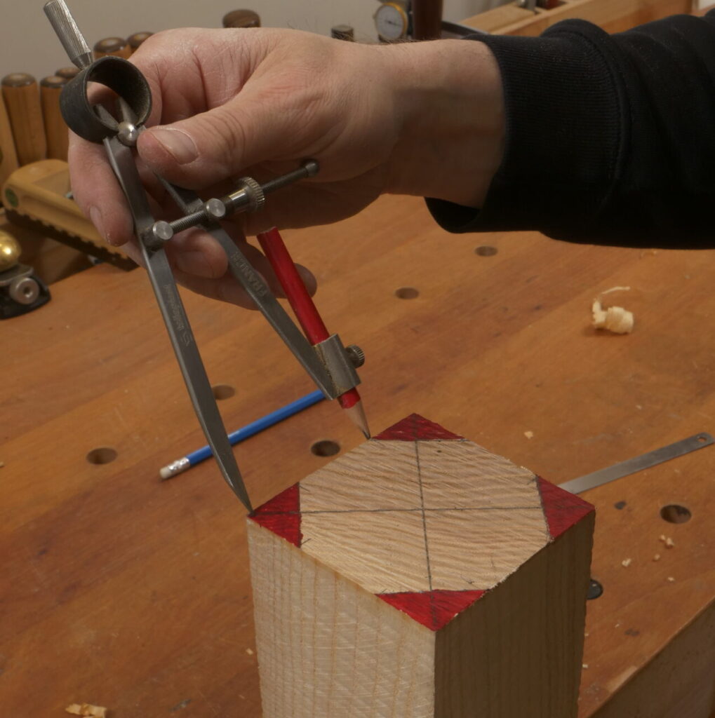 Ein Achteck wird mit Hilfe eines Zirkels auf den Pfosten eingezeichnet.