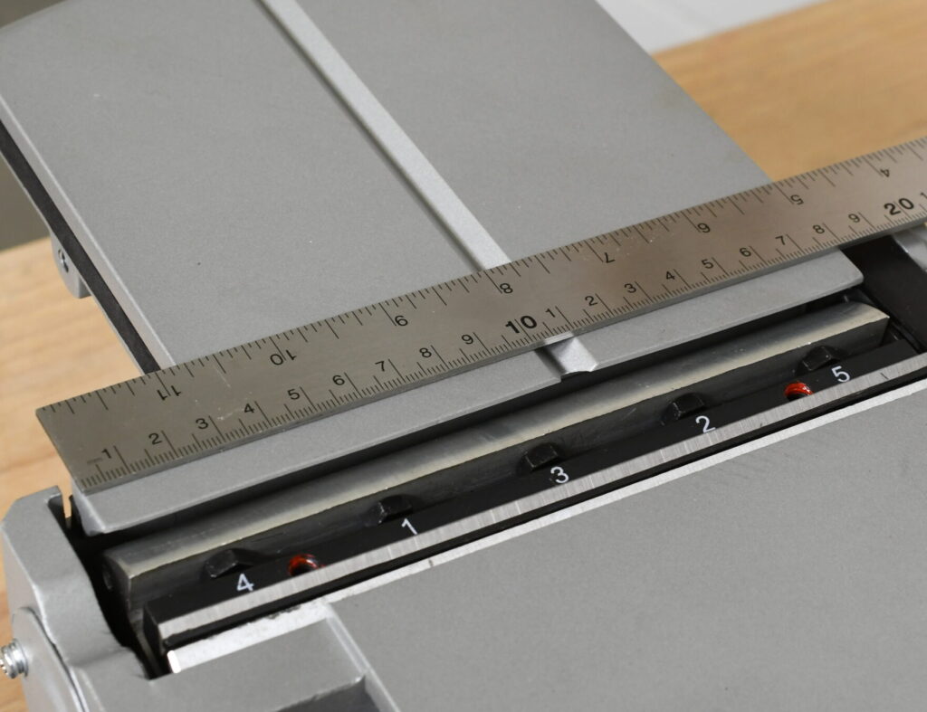 Ein Linial wird an die Hobelmesser gehalten, um die Hobelweite von 180 mm zu messen.