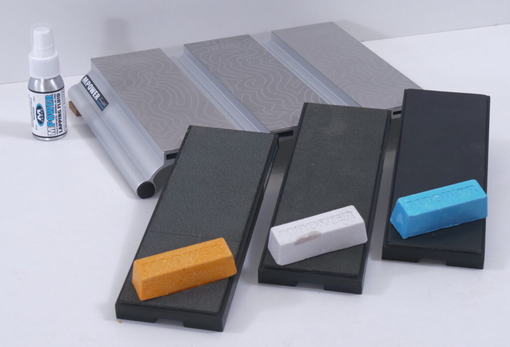 Das Schärfsystem von MPower im Überlick mit dem Aluminium-Träger, den drei Schutzkappen und der Läppflüssigkeit.