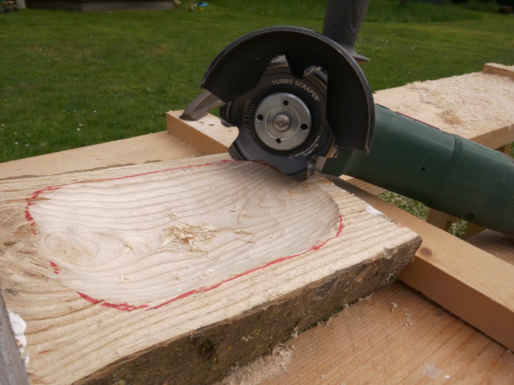 Der Turboscraper ist auf einen Winkelschleifer montiert und liegt neben einer grob ausgearbeiteten Holzschale.