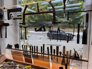 Das Schaufenster eines Restaurators, in dem Werkzeug in Plexiglashaltern eingehängt ist.