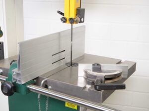 Der Queranschlag und der Parallelanschlag der Bandsäge auf dem Maschinentisch