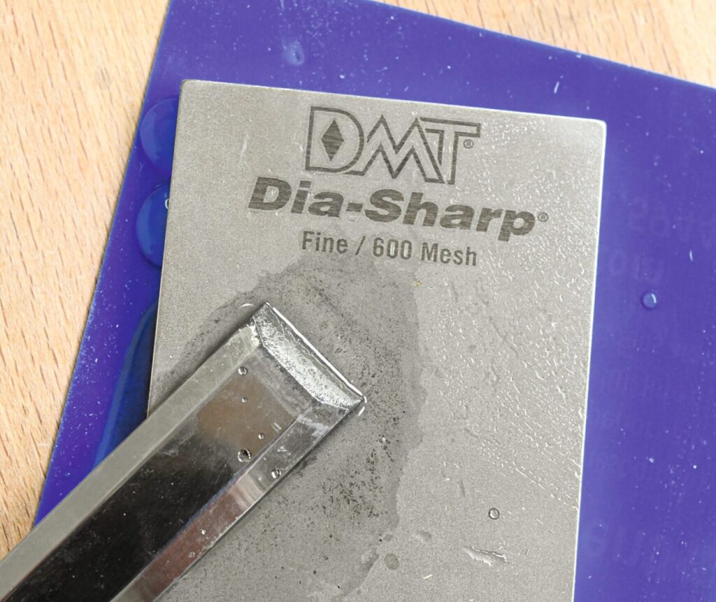 Ein Stechbeitel wird auf einem Dia-Sharp-Schärfstein geschärft.