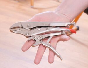 Eine Gripzange liegt auf einer Handfläche.