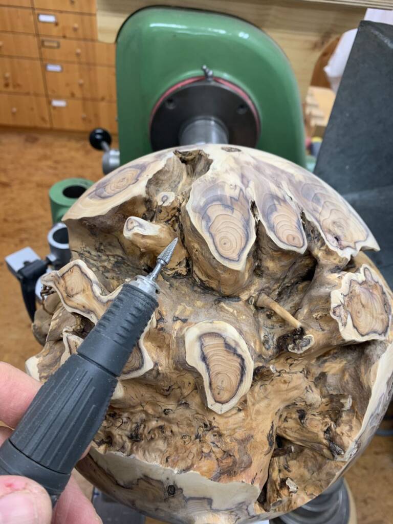 Die Kugel aus der Eibenwurzel wird auch mit dem Dremel bearbeitet. So entfernt der Drechsler Kai Köthe den Schmutz zwischen den Wurzeln.