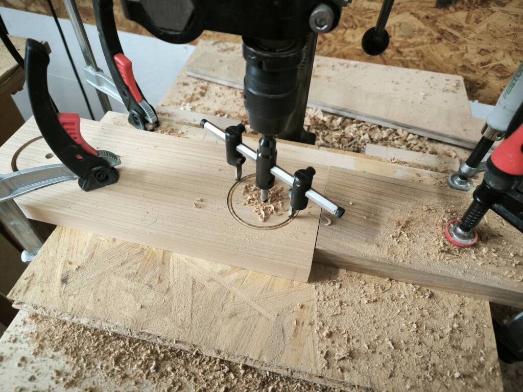 Detailbild: Die runde Aussparung im Getränkehalter wird am Bohrständer gebohrt.