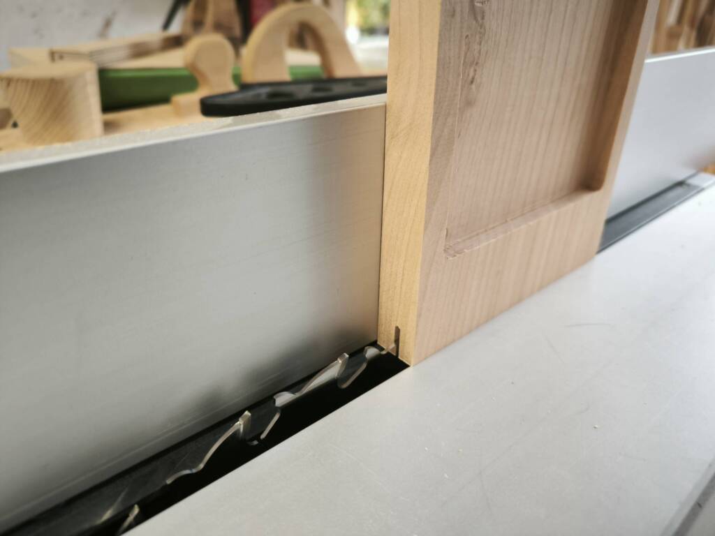 Ein Werkstück vor dem Auftrennen hochkant auf einer Kreissäge.