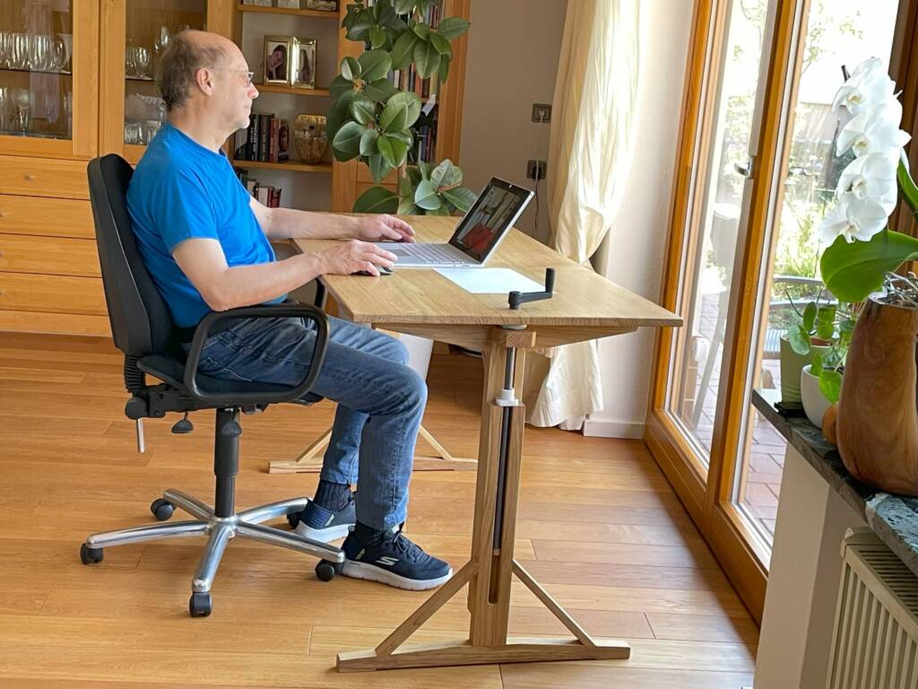 Ein Mann sitzt an einem Schreibtisch.