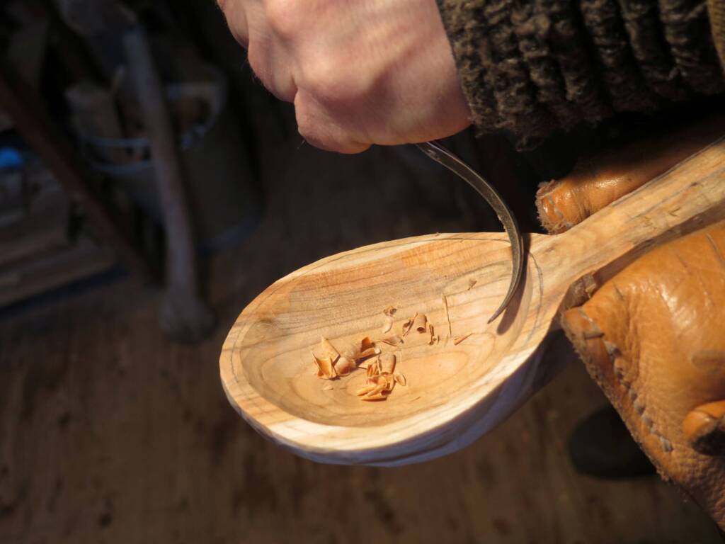 Löffel wird mit Schnitzmesser ausgehöhlt, feine Späne im Inneren sichtbar